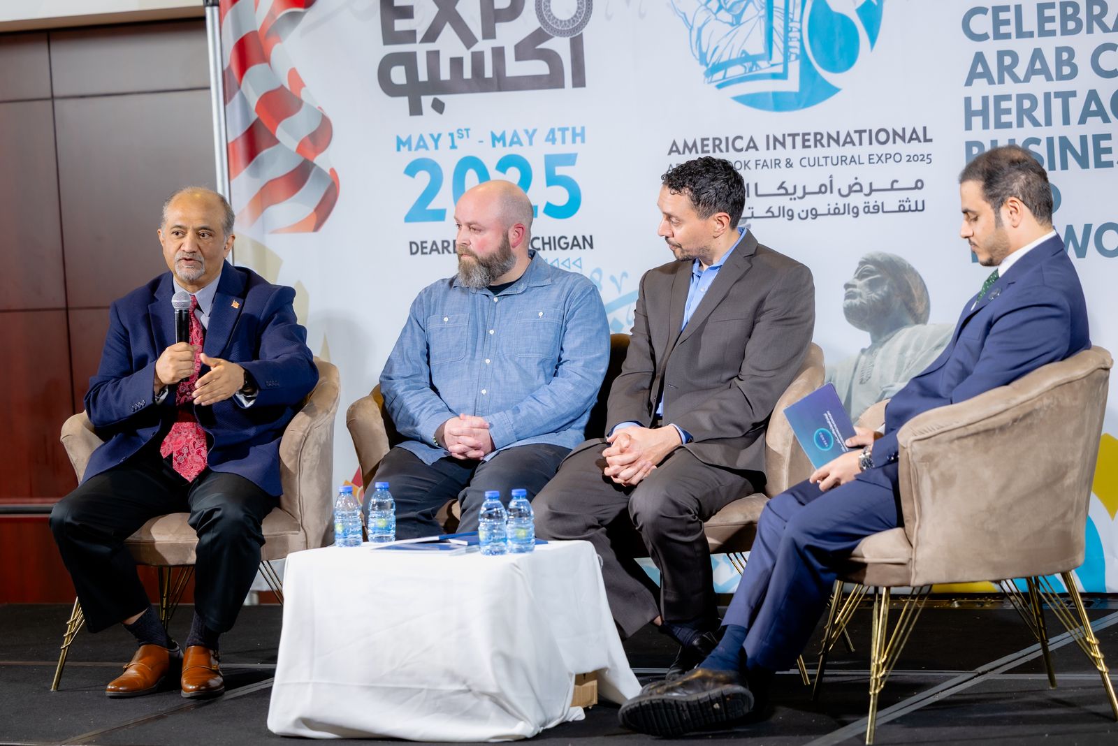 Panel discussion on stage in front of the Arab-America Expo 2025 backdrop in Dearborn